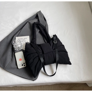 Détail du sac cabas matelassé noir en forme de nœud avec bandoulière rembourrée et double sangle