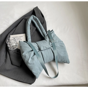 Vue détaillée du sac cabas matelassé bleu clair avec design noeud et bandoulière
