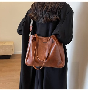 Dettaglio borsa shopper vintage marrone con texture in pelle e tracolla a fantasia