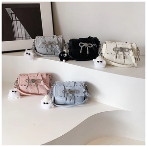 Detail of woven square bags in five colors with bow buckle and plush charms