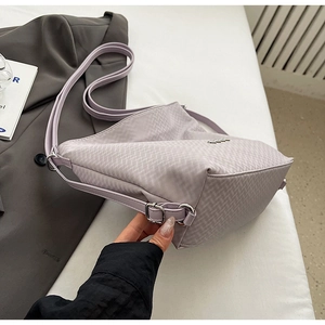 Detail of lavender tote bag with quilted fabric texture and adjustable silver hardware