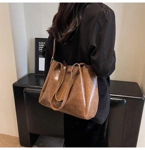 Borsa tote in pelle marrone con tracolla larga indossata dalla modella vista da dietro