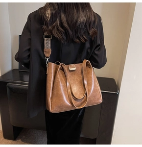 Dettaglio borsa tote vintage marrone con ampia tracolla in tessuto jacquard e fibbie oro