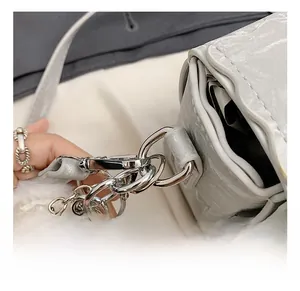 Close-up of metallic silver crossbody bag showing high-quality metal hooks and hardware