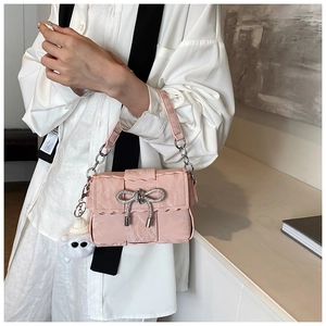 Pink pleated crossbody bag featuring a rhinestone bow and fuzzy eye charm detail