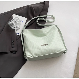 Detail of mint green quilted nylon shoulder bag with four silver heart-shaped buckles