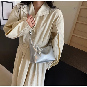 Détail du sac hobo argenté avec texture plissée et breloque noeud en perles
