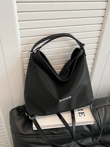 Minimalist black woven hobo tote bag with silver hardware and adjustable strap