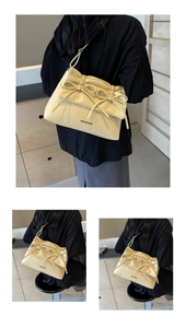 Detail of light yellow ballet style shoulder bag with pleated texture and bows