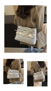 Close-up of silver pleated leather shoulder bag featuring stylish double bow detail