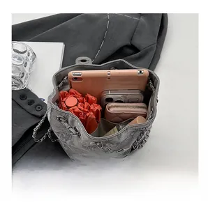 Interno di una borsa a secchiello grigia marmorizzata con cellulare e ombrello