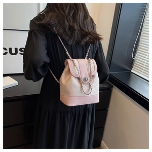 Vista posteriore di una modella con mini zaino rosa con catena e trama jacquard pregiata