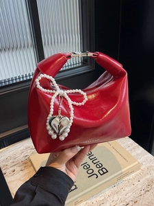 Sac à main rouge brillant en demi-lune avec nœud en perles blanches et charme cœur