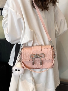 Pink crossbody bag with woven texture, diamond bow, and cute plush monster charm