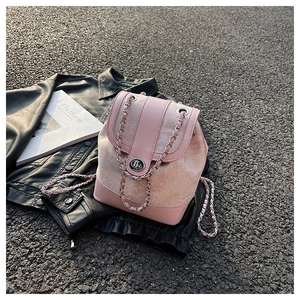 Dettaglio borsa a secchiello rosa con trama floreale a rilievo e tracolla a catena