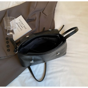 Detailed interior of black crinkled leather crossbody bag with silver magnetic snap