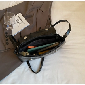 Detail shot of black wrinkled leather bag showing inner lining and daily storage capacity