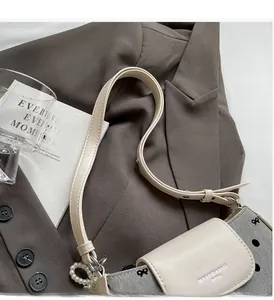 Detail of the chic polka dot crossbody bag with pearl charm and black bow accents