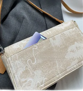 Detail of beige shoulder bag featuring plant patterns and a functional back card pocket
