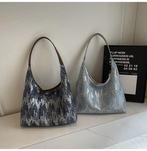 Close-up of sequined denim shoulder bag with metallic textures in blue and silver