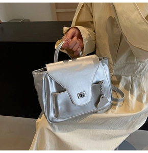 Détail du sac à main argenté brillant avec pendentif en forme de cœur et fermoir en métal
