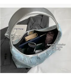 Detail shot of large capacity interior of blue sequin denim tote holding daily essentials