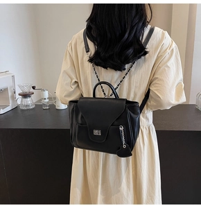 Détail du sac multifonction noir avec fermoir métallique et breloque cœur porté par mannequin