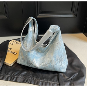 Detailed view of light blue denim tote with silver sequins and metallic shoulder strap