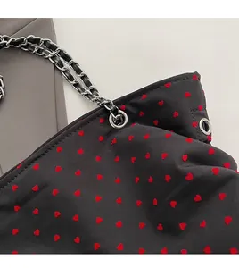 Detailed close-up of heart pattern fabric and silver metal chain strap on tote bag