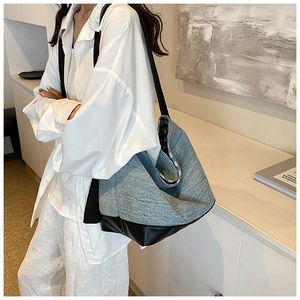Detail of blue textured tote bag with black leather bottom and stylish gingham lining