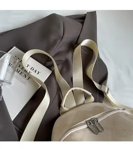 Detail of beige backpack featuring premium fabric texture and durable metal dual zippers