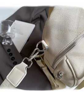 Detail of silver hardware and cream canvas texture on minimalist casual backpack