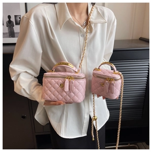 Detail of pink quilted leather box bags with gold chain straps and metal handles