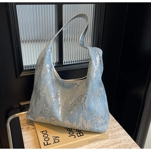 Detail of light blue denim tote with shimmering silver sequins in a wavy pattern