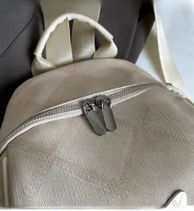 Close-up of smooth metal double zippers and woven texture on beige fashion backpack
