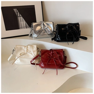 Detail of four stylish bucket bags with ribbons in silver black beige and red colors