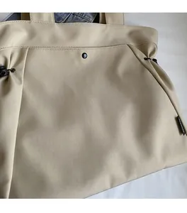 Detail of soft canvas tote bag with black snap button and drawstring closure