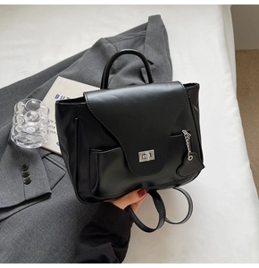 Détail d'un sac à dos noir en cuir PU avec fermoir rotatif argenté et breloque cœur