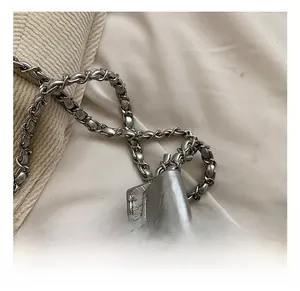 Close-up of metallic silver faux leather texture and elegant silver woven chain strap