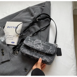Detail of dark grey jacquard crossbody bag with abstract patterns and dual straps