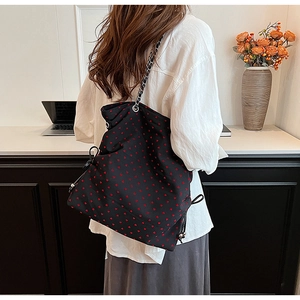 Detailed back view of large black tote bag with red heart print and chain strap