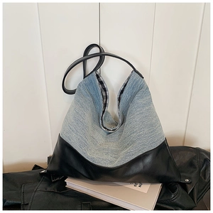 Detail of light blue denim tote with black leather trim and checkered inner lining