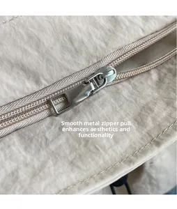 Detailed macro view of smooth silver metallic zipper pull on pleated fabric bag