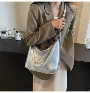 Dettaglio della borsa hobo argento con eleganti perle e catene su pelle martellata di qualità
