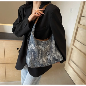 Detail of grey-blue canvas hobo bag with silver sequin stripes and brown leather strap