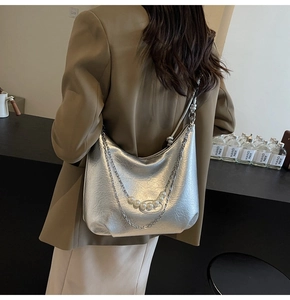 Dettaglio della borsa hobo argento metallizzato con catena spessa e ciondoli di perle