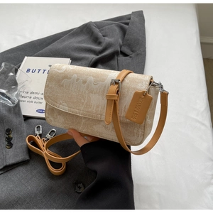 Detail of beige jacquard bag featuring orange leather strap and premium buckle hardware