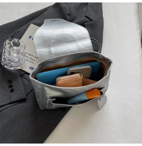 Vue intérieure montrant la grande capacité du sac argenté métallisé avec objets du quotidien