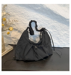 Detailed view of the black pleated nylon hobo bag featuring decorative drawstrings