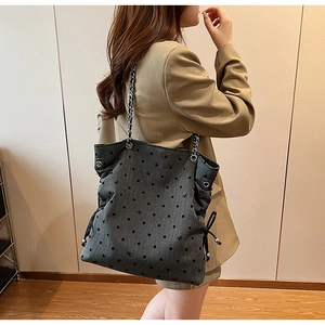Detail of grey polka dot tote bag with silver chain strap and drawstring closure